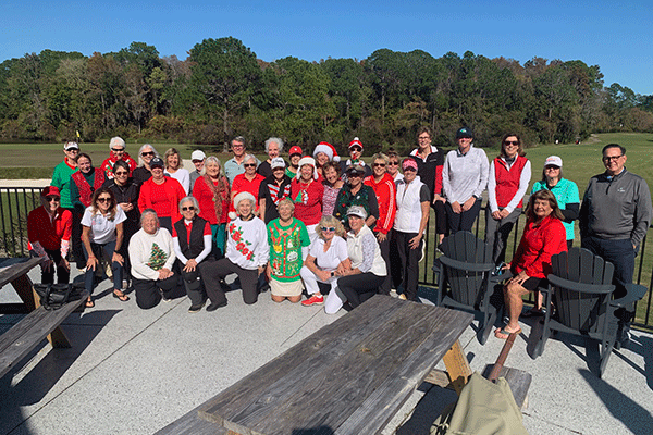 The Ladies Golf Association posing for a photo outside wearing Christmas sweaters